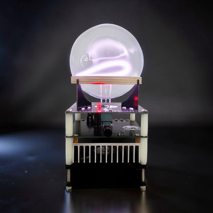 The Curious Mind Xenon Ion Ring Glass Sphere interactive science display with glowing purple plasma inside a clear glass orb on a black base with electronic components.